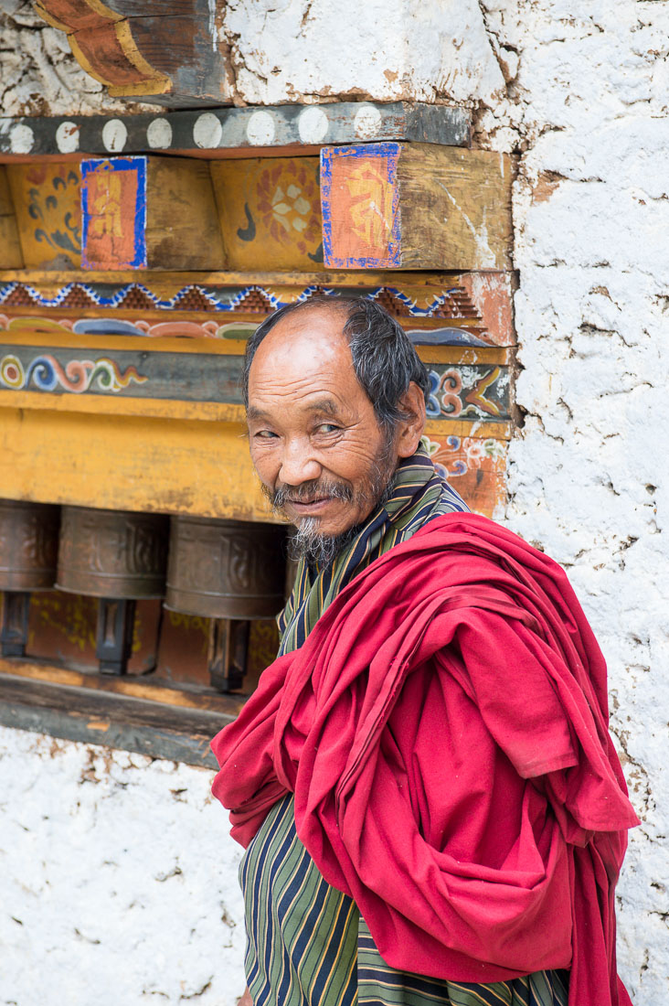 Old man at the Gomkora Buddhist monastery performing the ritual walking around the temple, Kingdom of Bhutan, Asia