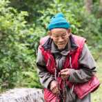 Old man from the countryside praying using the Buddhist malas (prayer beads), Kingdom of Bhutan, Asia