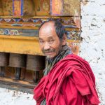 Old man at the Gomkora Buddhist monastery performing the ritual walking around the temple, Kingdom of Bhutan, Asia