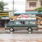 Mercedes minivan made in Korea loaded with passengers and a lot of merchandise; Phnom Penh, Kingdom of Cambodia, Indochina, South East Asia.