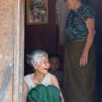 Old woman with her family, sitting in front of the front door, having good time. Virachey National Park, Ratanakiri province, Kingdom of Cambodia, Indochina, South East Asia