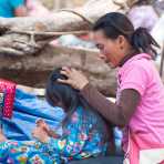 Woman busy in removing pets from the hair of her daughter, Sen Monorom, Mondulkiri province. Kingdom of Cambodia, Indochina, South East Asia.