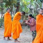 Young buddhist monks collecting food alms, Kratie, Kompong Chan province. Kingdom of Cambodia, Indochina, South East Asia