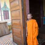 Buddhist monk at the entrance of the Wat Ounalom. Phnom Penh, Kingdom of Cambodia, Indochina, South East Asia.