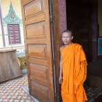 Buddhist monk at the entrance of the Wat Ounalom. Phnom Penh, Kingdom of Cambodia, Indochina, South East Asia.