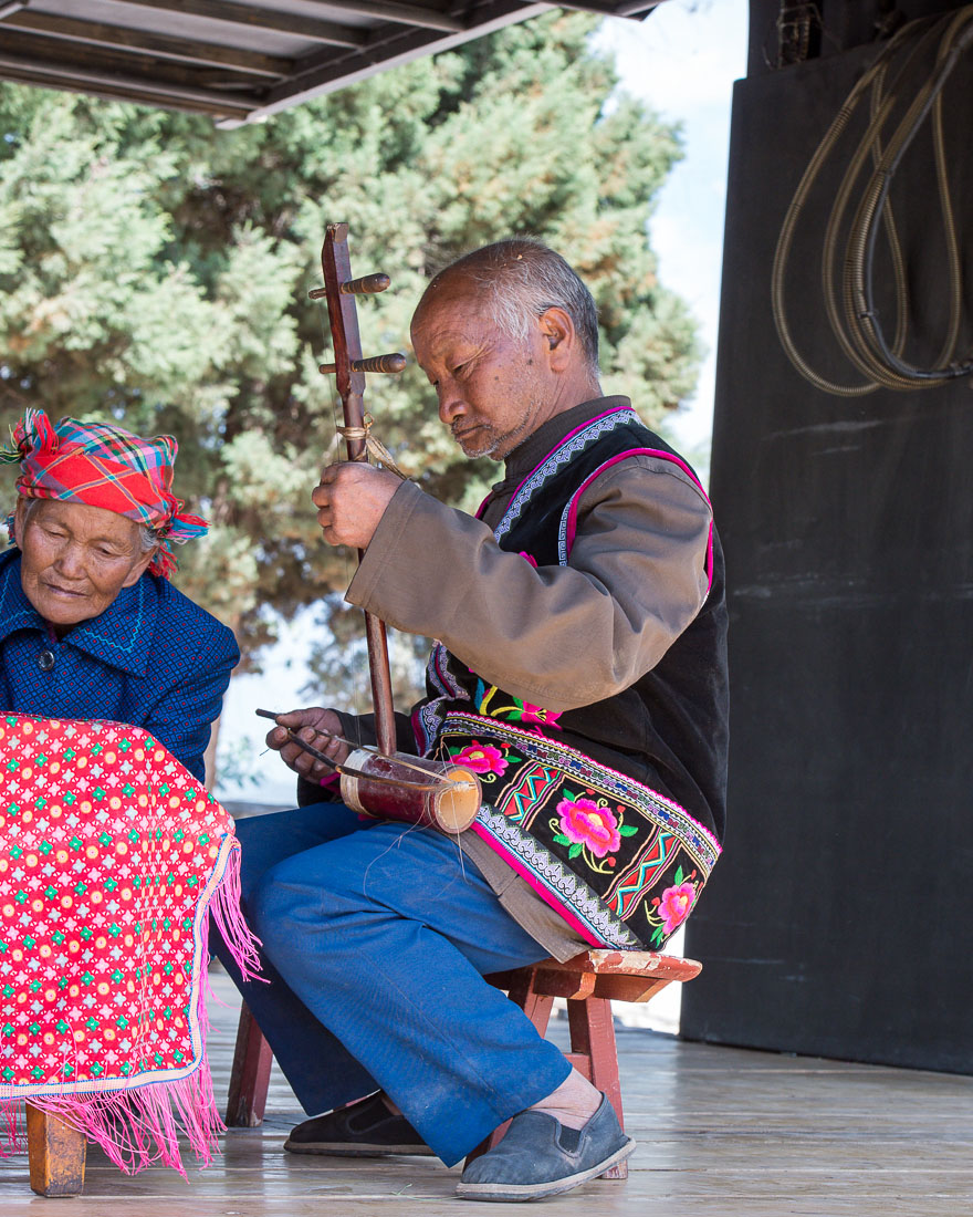 An old musician from the Miao ethnic minority people, playing an ancient string musical instrument. Mao Jie village, Wuding County, Yunnan Procince, China, Asia. Nikon D4, 24-120mm, f/4.0, VR