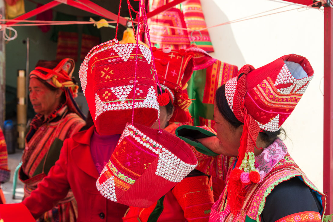Colorful hats worn by the women from the Pu La Yi ethnic minority people, on sale at the Xi Bei Le market, Meng Zi city, Yunnan Province, China, Asia. Nikon D4, 24-120mm, f/4.0, VR