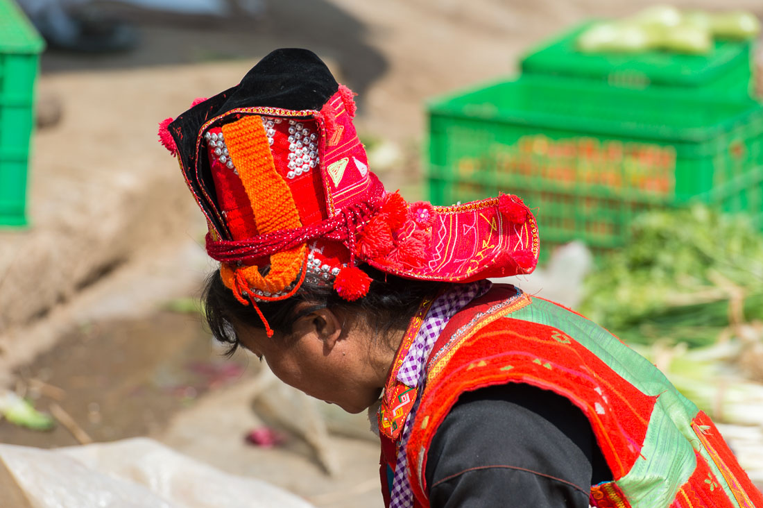 Colorful hat worn by the women from the Pu La Yi ethnic minority people, at the Xi Bei Le market, Meng Zi city, Yunnan Province, China, Asia. Nikon D4, 70-200mm, f/2.8, VR II