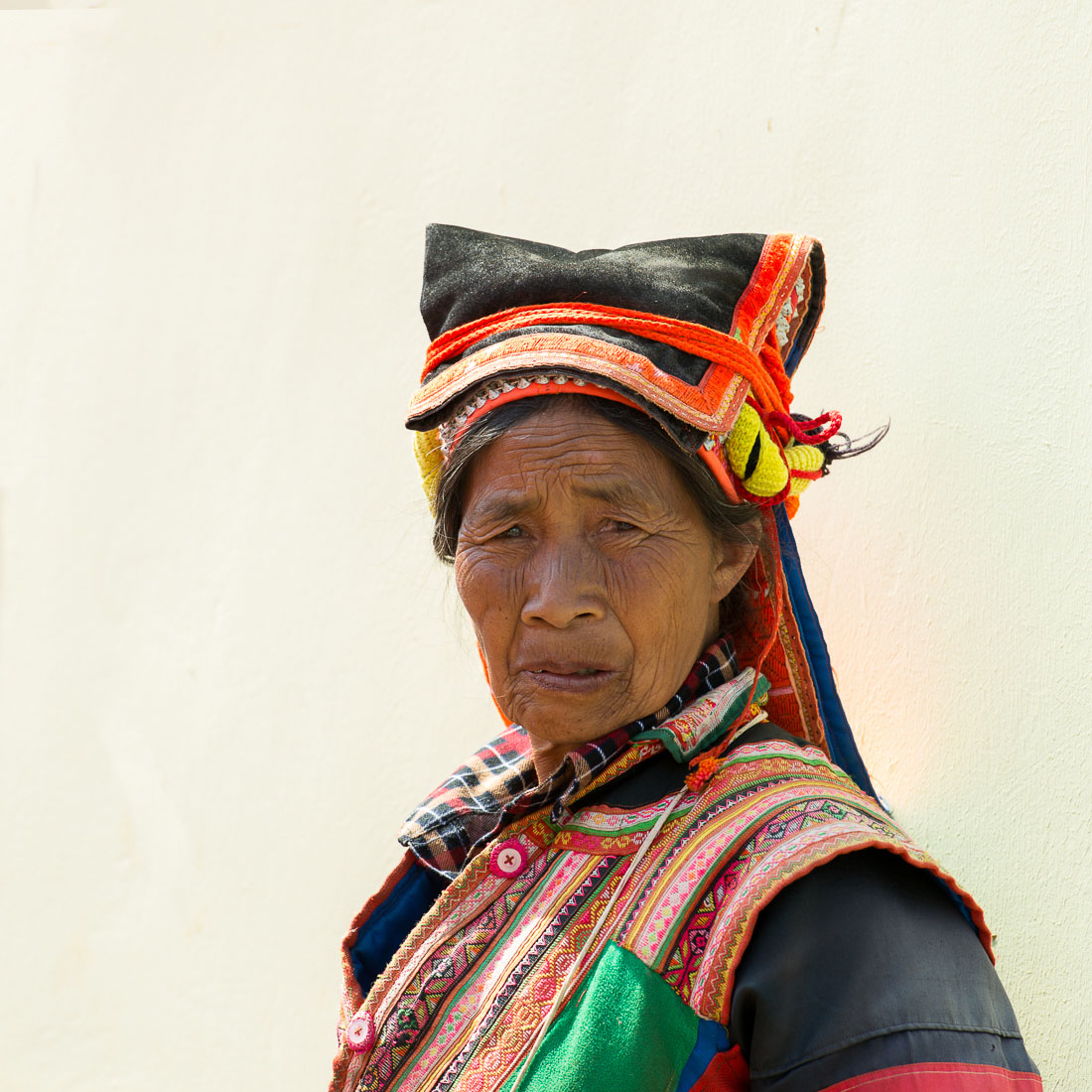 A woman from the Pu La Yi ethnic minority people, wearing the traditional colorful costume at the Xi Bei Le market, Meng Zi city, Yunnan Province, China, Asia. Nikon D4, 70-200mm, f/2.8, VR II