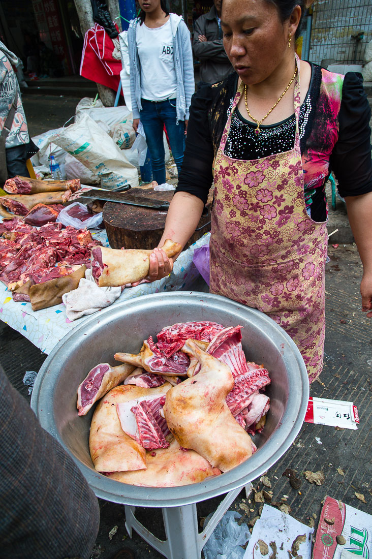 A butcher specialized in dog meat offering half leg at the Lan Cang market, Yunnan Province, China, Asia. Nikon D4, 24-120mm, f/4.0, VR