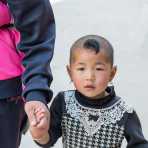 Little girl from the Yi ethnic minority people, with a funny air cut, at the Jia Yin village market, Hong He county, Yunnan Province, China, Asia. Nikon D4, 24-120mm, f/4.0, VR