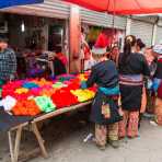 Women from the Yao ethnic minority people wearing the traditional costume at Jin Ping market buying colorful cotton yarn. Jin Ping County, Yunnan Province, China, Asia. Nikon D4, 24-120mm, f/4.0, VR