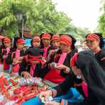 A group of women from the Yao ethnic minority people wearing the traditional costume at Jin Shui He market buying colorful trimming. Jin Ping County, Yunnan Province, China, Asia. Nikon D4, 24-120mm, f/4.0, VR