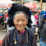 A joyful woman from the Ha Ni ethnic minority people, wearing the traditional costume,  at Jin Shui He market, Jin Ping County, Yunnan Province, China, Asia. Nikon D4, 24-120mm, f/4.0, VR