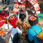 Women from the Ha Ni ethnic minority people in traditional costumes, buying apples at the Ping He market, Lu Chun County, Yunnan Province, China, Asia. Nikon D4, 24-120mm, f/4.0, VR