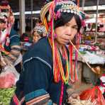 Woman from the Ha Ni ethnic minority people in colorful costume, smoking the traditional pipe. Mang Xin market, Meng Lian County, Yunnan Province, China, Asia. Nikon D4, 24-120mm, f/4.0, VR