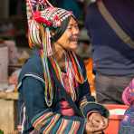 Joyful woman from the Ha Ni ethnic minority people in colorful costume, at Mang Xin market, Meng Lian County, Yunnan Province, China, Asia. Nikon D4, 70-200mm, f/2.8, VR II