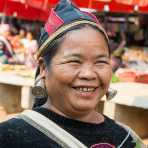 A joyful woman from the Bulang ethnic minority people wearing the unique traditional earring. Mang Xin market, Meng Lian County, Yunnan Province, China, Asia. Nikon D4, 70-200mm, f/2.8, VR II