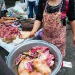 A butcher specialized in dog meat offering half leg at the Lan Cang market, Yunnan Province, China, Asia. Nikon D4, 24-120mm, f/4.0, VR