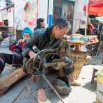 Cobbler at work; Jia Yin market, Yunnan Province, China, Asia. Nikon D4, 24-120mm, f/4.0, VR