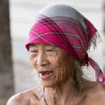 An old woman from the Khamu people ethnic minority, chewing paan (areca nuts and betel leaves) which stains in red the teeth and the mouth area. Luang Mantha province, Lao PDR, Indochina, South East Asia