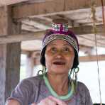 Woman from the Akha Chijor people etnic minority wearing the traditional elaborate hat.  Luang Namtha province, Lao PDR, Indochina, South East Asia.