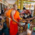 Buddhist monks collecting offers from worshippers during the Buddhist celebration of the Khao Phansaa, the three months lent and rain retreat for the monks, Wat Prabat, Pakse, Lao PDR, Indochina, South East Asia.