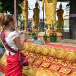 Woman offering incense sticks during the Buddhist celebration of the Khao Phansaa, the three months lent and rain retreat for the monks, Wat Prabat, Pakse, Lao PDR, Indochina, South East Asia.