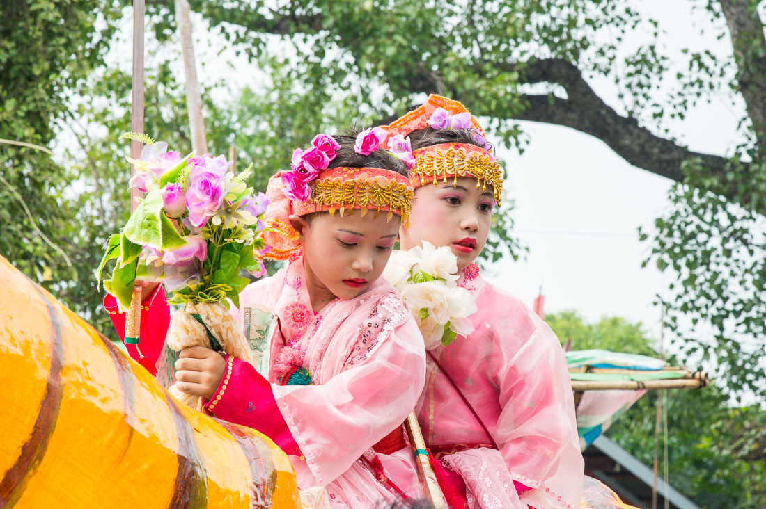 Two little girls wearing costumes, riding an animated tiger made out of paper mache, Manhua Village, Myanmar, Indochina, South East Asia