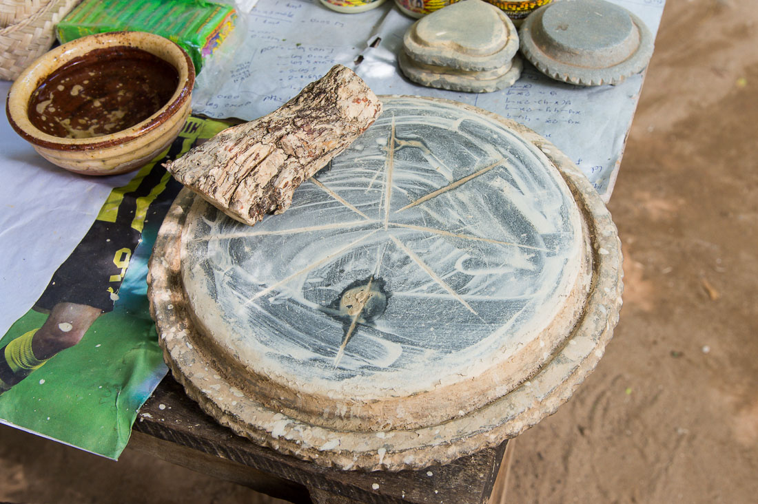 Roots and grinding plate to prepare Tha Nat Khar a natural cosmetic most Burmese women and man put on their face and arms for sun protection. Mingo Village, Sagaing Province, Myanmar, Indochina, South Easr Asia.