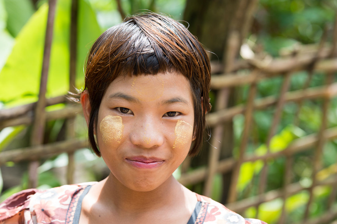 Young and beautiful girl from thre Chin Village, her face with patches of Tha Nat Khar an extract from tree roots commonly used to protect the skin from the sun.. Rakhine State, Myanmar, Indochina, South East Asia.