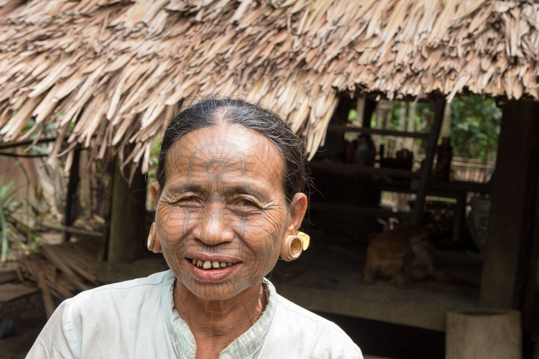 Old woman with the face full covered from spider web tattos, a mysterious and old tradition which was practiced until 60 years ago. There are 7 villages on the Lamro river with about 20 old women left with spider web tattoos on their face, all aged more than 65 years. Chin Village, Rakhine State, Myanmar, Indochina, South East Asia.