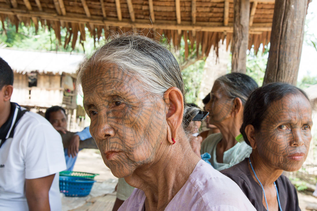 Old woman with the face full covered from spider web tattos, a mysterious and old tradition which was practiced until 60 years ago. There are 7 villages on the Lamro river with about 20 old women left with spider web tattoos on their face, all aged more than 65 years. Chin Village, Rakhine State, Myanmar, Indochina, South East Asia.