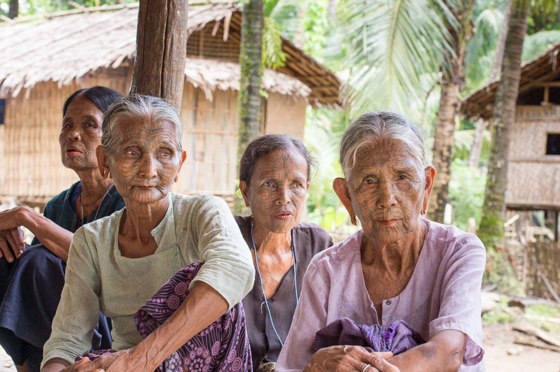 Four old women with the face full covered from spider web tattos, a mysterious and old tradition which was practiced until 60 years ago. There are 7 villages on the Lamro river with about 20 old women left with spider web tattoos on the face and all aged more than 65 years. Chin Village, Rakhine State, Myanmar, Indochina, South East Asia.