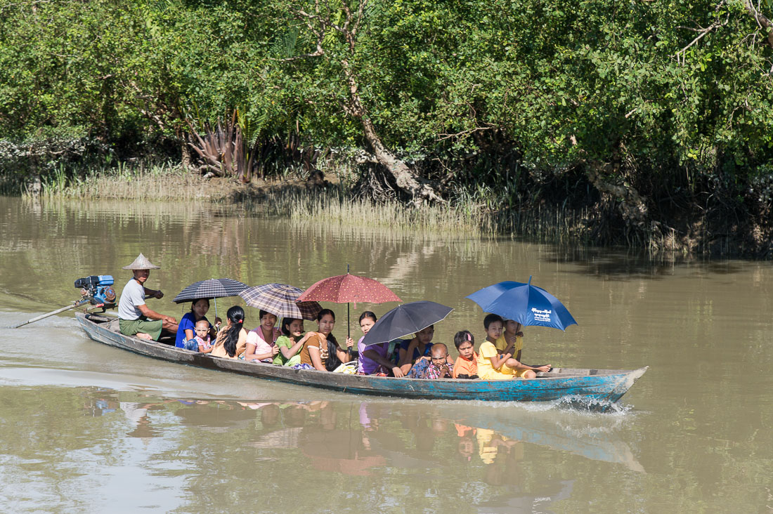Small skiff loaded with  villagers going to the market in Mrauk U, Kaladan river, Rakhine State, Myanmar, Indochina, South East Asia.