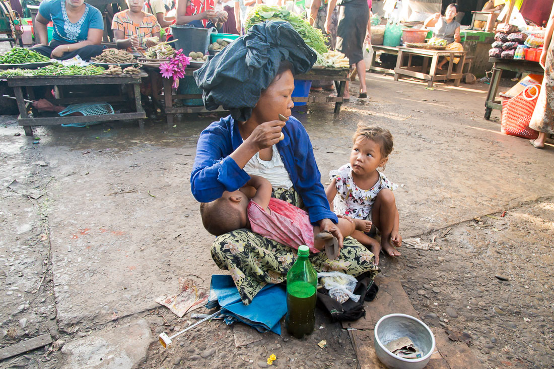 A mother with two children, singing and begging for money, while breastfeeding her youngest at the market in Sittwe, Rakhine State, Myanmar, Indochina, South East Asia. Nikon D4, 24-120mm, f/4.0, VR