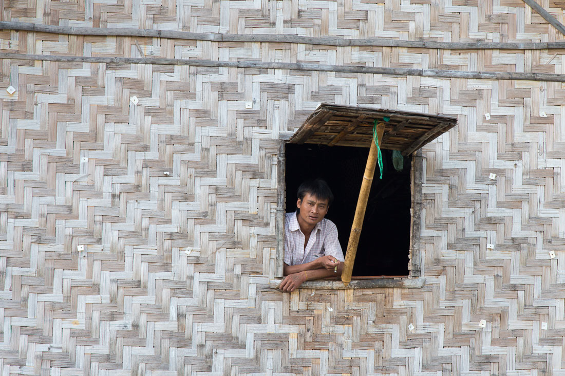 Man looking out his window, Inle Lake, Shan State, Mynamar, Indochina, South East Asia.