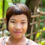 Young and beautiful girl from thre Chin Village, her face with patches of Tha Nat Khar an extract from tree roots commonly used to protect the skin from the sun.. Rakhine State, Myanmar, Indochina, South East Asia.