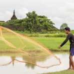 Experienced fisherman casting his net on a pond near the ancient Buddhist temples in Mrauk U Village, Rakhine State, Myanmar, Indochina, South East Asia.
