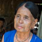 Old woman with the face full covered from spider web tattos, a mysterious and old tradition which was practiced until 60 years ago. There are 7 villages on the Lamro river with about 20 old women left with spider web tattoos on their face, all aged more than 65 years. Chin Village, Rakhine State, Myanmar, Indochina, South East Asia.