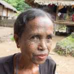 Old woman with the face full covered from spider web tattos, a mysterious and old tradition which was practiced until 60 years ago. There are 7 villages on the Lamro river with about 20 old women left with spider web tattoos on their face, all aged more than 65 years. Chin Village, Rakhine State, Myanmar, Indochina, South East Asia.