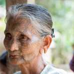 Old woman with the face full covered from spider web tattos, a mysterious and old tradition which was practiced until 60 years ago. There are 7 villages on the Lamro river with about 20 old women left with spider web tattoos on their face, all aged more than 65 years. Chin Village, Rakhine State, Myanmar, Indochina, South East Asia.