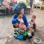 A mother with two children, singing and begging for money, while breastfeeding her youngest at the market in Sittwe, Rakhine State, Myanmar, Indochina, South East Asia. Nikon D4, 24-120mm, f/4.0, VR