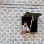 Man looking out his window, Inle Lake, Shan State, Mynamar, Indochina, South East Asia.