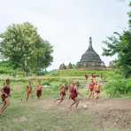 Young novice Buddhist monks playing soocer (football) just in front of Ratanabon Pagoda, in late afternoon, Mrauk U Village, Rakhine State, Myanmar, Indochina, South East Asia.