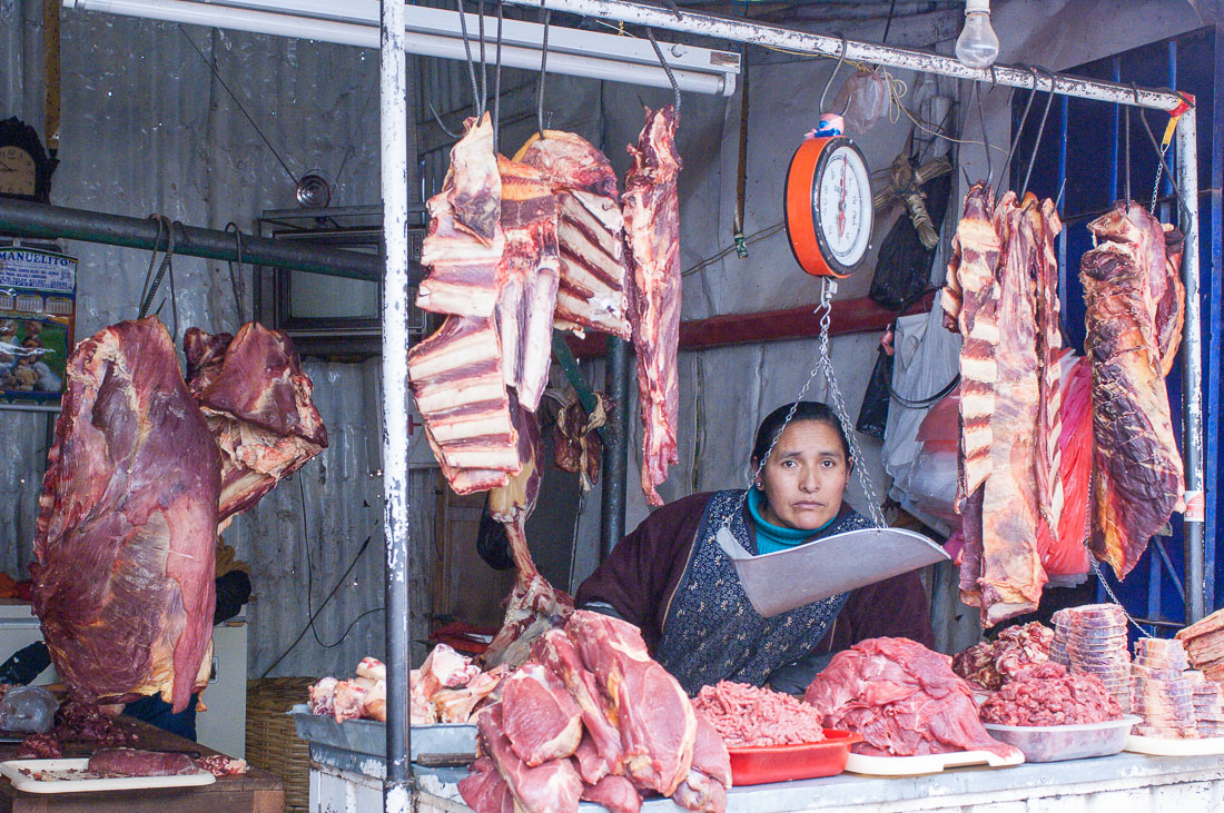 A butcher selling meat at Cuzco market, Peru, South America