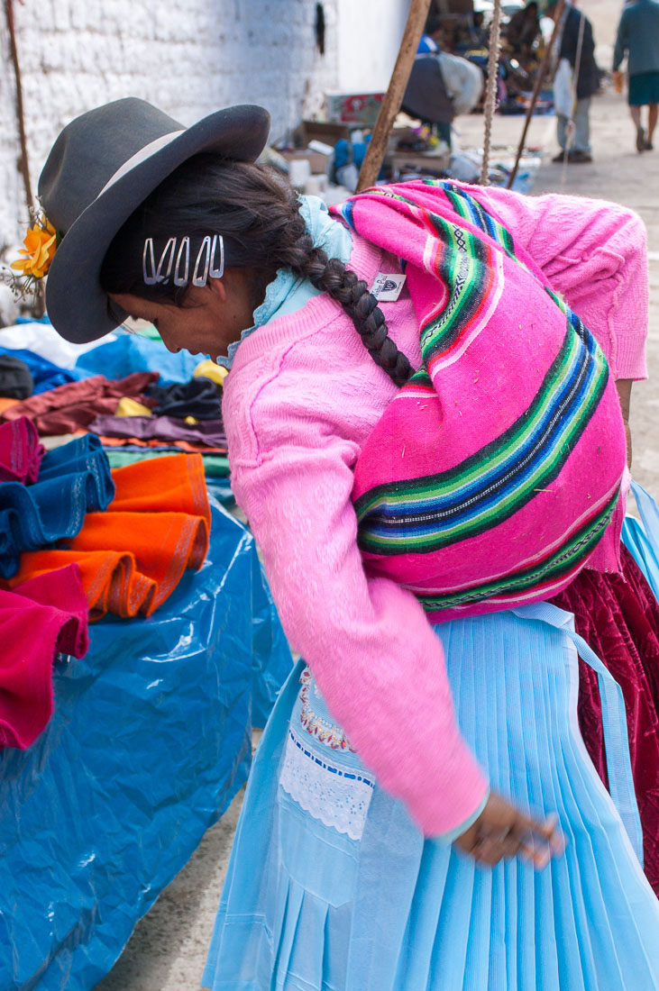 Young woman wearing traditional costume and hat, buying at the market in Chavin, Peru, South America