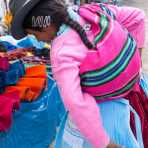 Young woman wearing traditional costume and hat, buying at the market in Chavin, Peru, South America