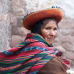 Woman wearing traditional costume and hat spinning wool in the street of Cuzco, Peru, South America