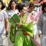 Female psychic medium follower of the Bang New Shrine with two long needles pierced through her cheeks, taking part in a street procession during the Chinese annual vegetarian festival. Phuket, Kingdom of Thailand, Indochina, South East Asia